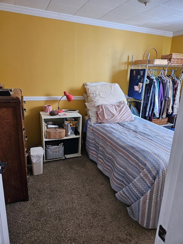 bedroom with dark colored carpet and ornamental molding