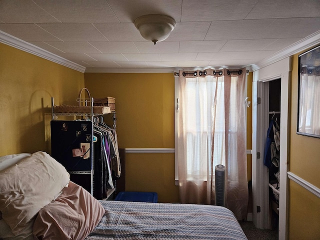 bedroom with crown molding and a closet