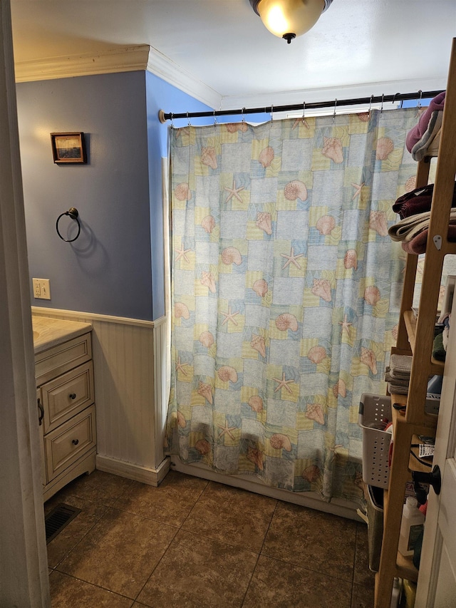 bathroom with tile patterned floors, crown molding, vanity, and shower / tub combo