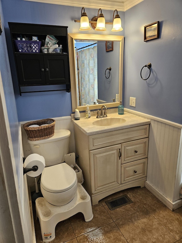 bathroom featuring toilet, tile patterned flooring, vanity, and ornamental molding