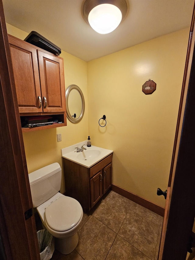 bathroom with toilet, vanity, and tile patterned floors