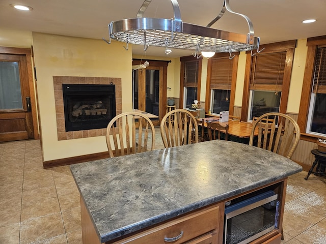 dining space featuring light tile patterned floors and a tiled fireplace