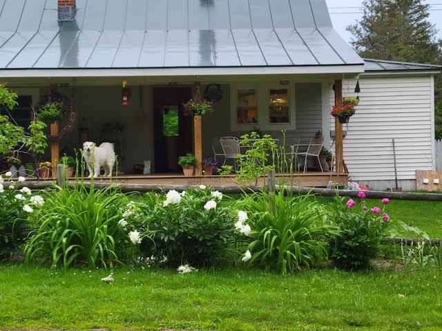 doorway to property with a porch and a lawn