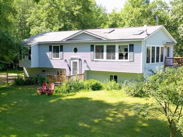 view of front facade with a deck and a front lawn