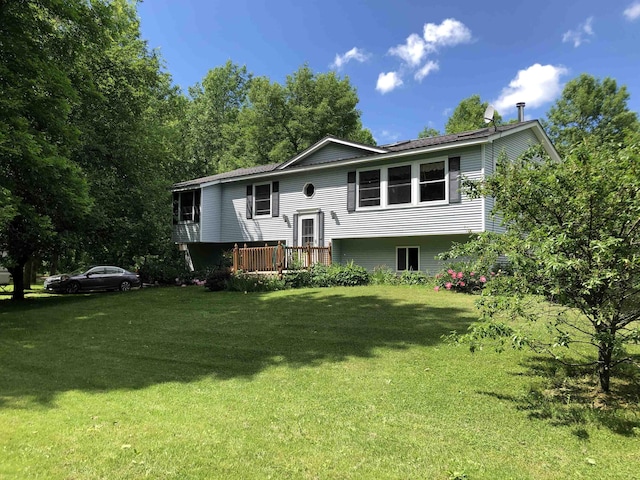 back of house featuring a lawn and a wooden deck