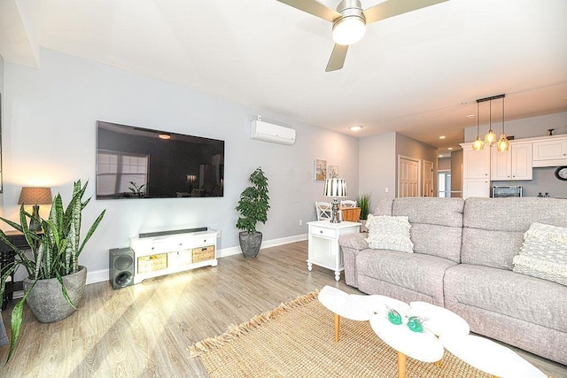 living room with light wood-type flooring, a wall unit AC, and ceiling fan