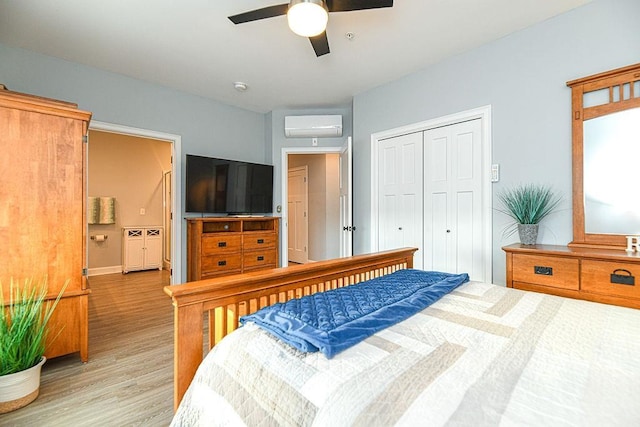 bedroom featuring light hardwood / wood-style flooring, a wall mounted AC, and ceiling fan