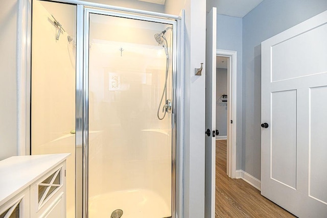 bathroom featuring hardwood / wood-style flooring and an enclosed shower