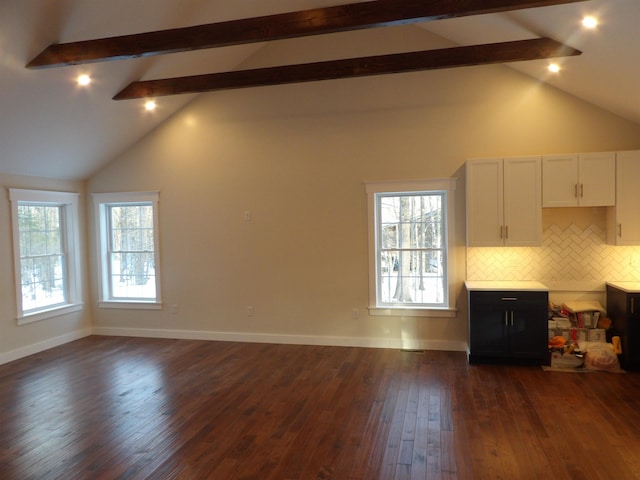 unfurnished living room featuring beamed ceiling, a healthy amount of sunlight, dark hardwood / wood-style floors, and high vaulted ceiling