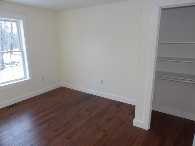 empty room with dark hardwood / wood-style flooring