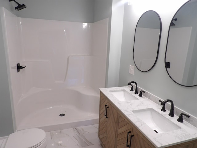 bathroom featuring vanity, toilet, and a shower