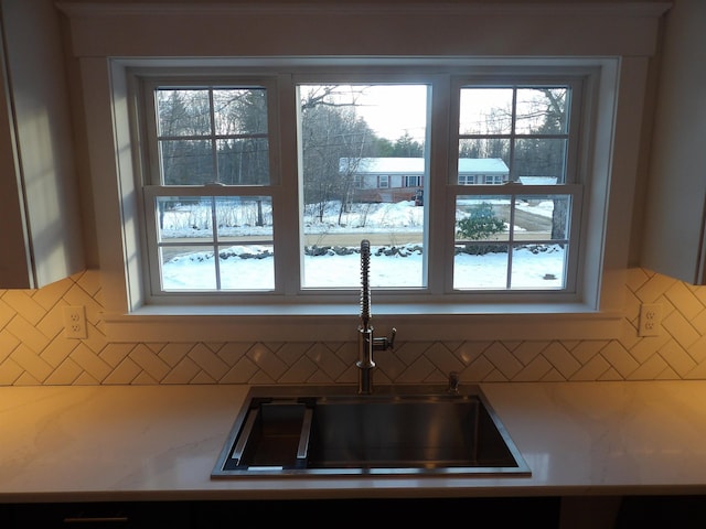 kitchen featuring tasteful backsplash, plenty of natural light, and sink