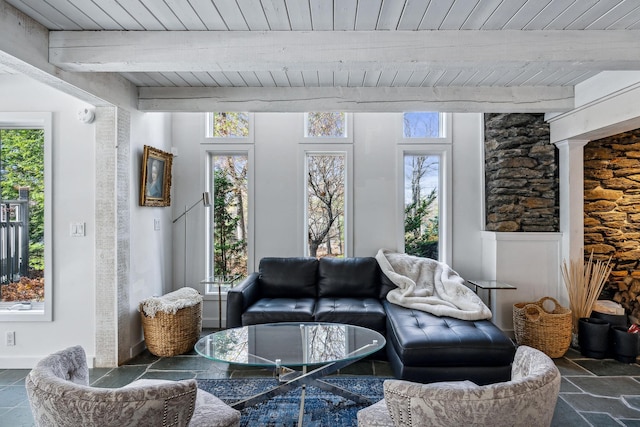 living room with a wealth of natural light, beamed ceiling, and wood ceiling