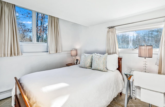 tiled bedroom with a baseboard radiator and multiple windows