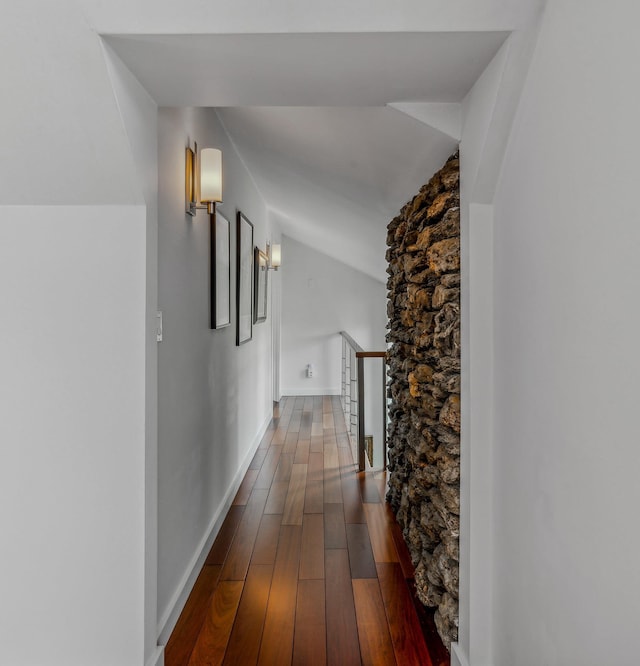 hall featuring wood-type flooring and lofted ceiling