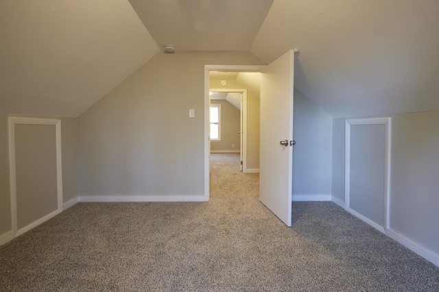 bonus room featuring light colored carpet and vaulted ceiling