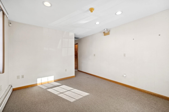 carpeted spare room with a baseboard heating unit