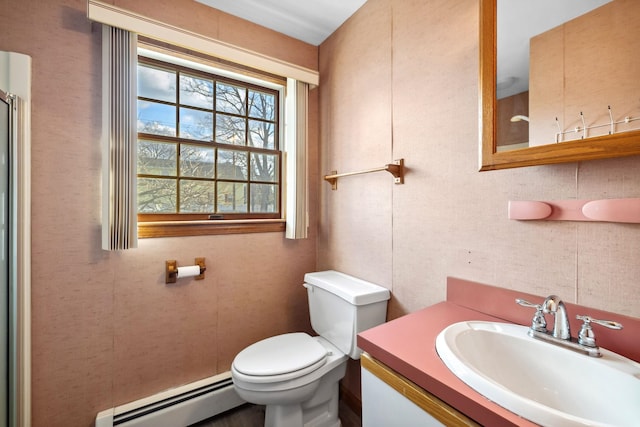 bathroom featuring vanity, toilet, and a baseboard heating unit