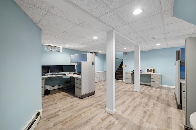 office featuring a paneled ceiling, light hardwood / wood-style floors, and a baseboard radiator