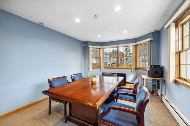 carpeted dining room with a baseboard heating unit