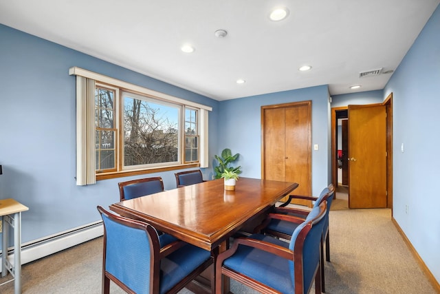 carpeted dining area featuring baseboard heating