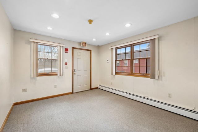 carpeted empty room featuring a baseboard radiator