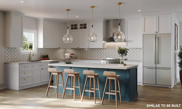 kitchen with sink, wall chimney exhaust hood, built in fridge, light hardwood / wood-style floors, and white cabinets