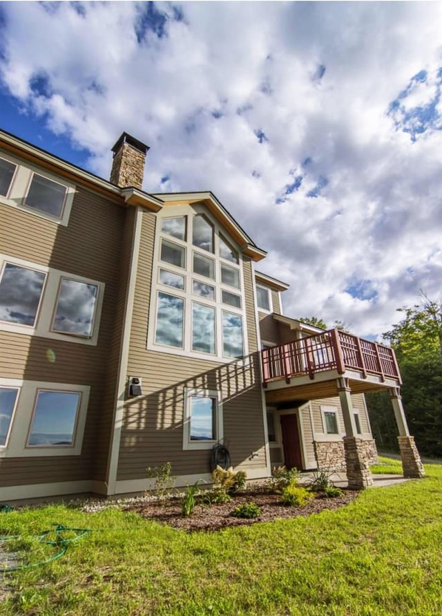 back of house with a lawn and a wooden deck