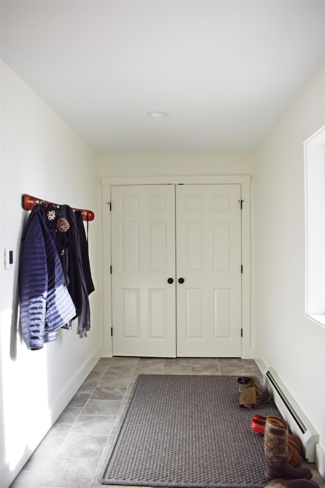 mudroom with light tile patterned flooring and baseboard heating