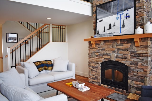 living room with hardwood / wood-style floors and a stone fireplace