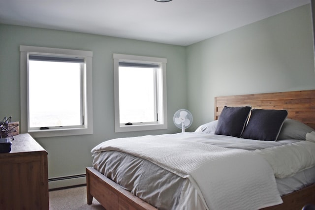 carpeted bedroom with baseboard heating and multiple windows