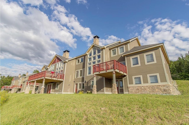 back of property with a wooden deck and a yard