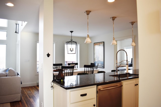 kitchen with stainless steel dishwasher, plenty of natural light, dark hardwood / wood-style floors, and sink