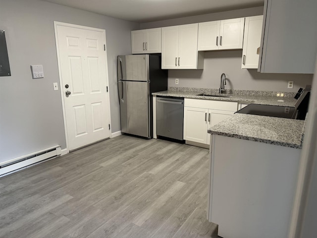 kitchen with white cabinetry, light stone countertops, stainless steel appliances, and light wood-type flooring