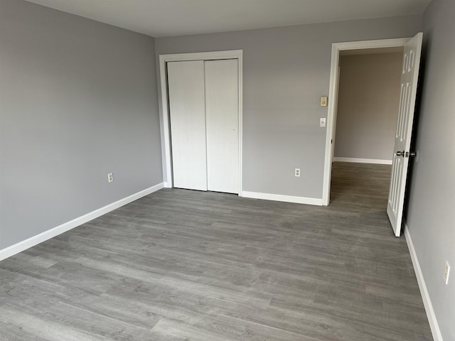 unfurnished bedroom featuring hardwood / wood-style flooring and a closet