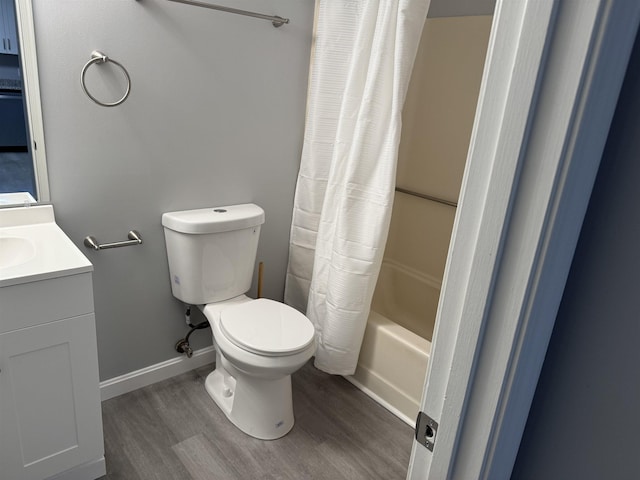 full bathroom featuring hardwood / wood-style floors, vanity, shower / bath combination with curtain, and toilet