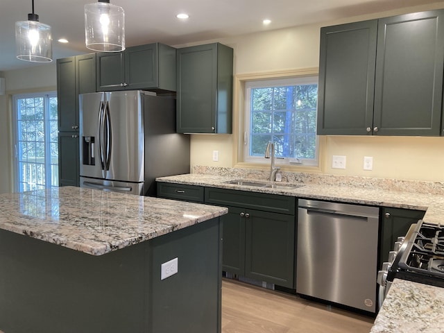 kitchen with sink, stainless steel appliances, plenty of natural light, and light wood-type flooring