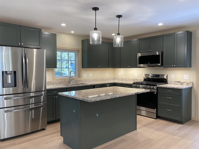 kitchen with sink, light stone counters, light hardwood / wood-style floors, a kitchen island, and appliances with stainless steel finishes