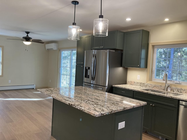 kitchen with appliances with stainless steel finishes, a kitchen island, a wealth of natural light, and sink