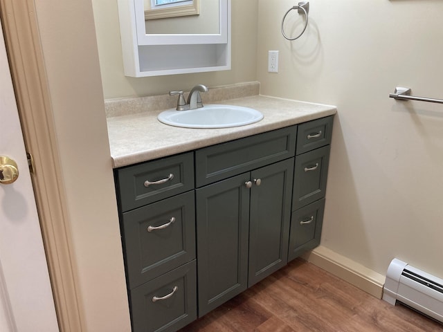 bathroom with hardwood / wood-style floors, vanity, and a baseboard radiator