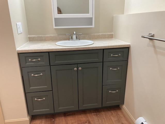 bathroom featuring vanity, hardwood / wood-style flooring, and a baseboard heating unit