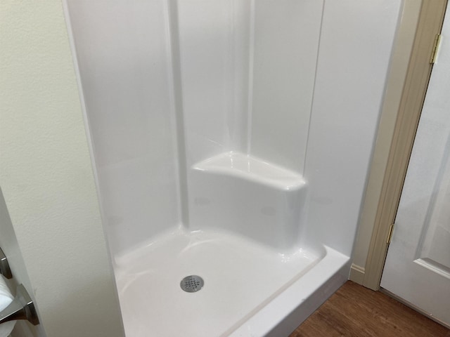 bathroom with hardwood / wood-style floors and a shower