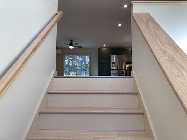 staircase featuring hardwood / wood-style flooring and ceiling fan