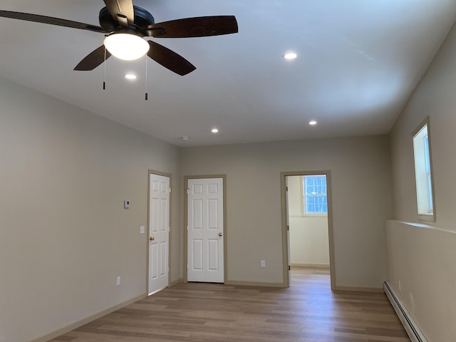 spare room featuring ceiling fan, a baseboard radiator, and light hardwood / wood-style floors