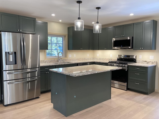 kitchen with a center island, sink, appliances with stainless steel finishes, and light hardwood / wood-style flooring