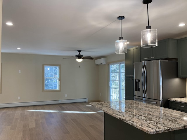 kitchen with ceiling fan, hanging light fixtures, stainless steel fridge with ice dispenser, an AC wall unit, and light wood-type flooring