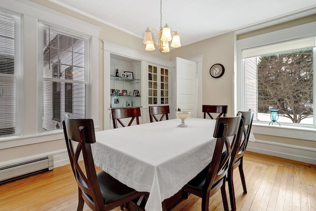 dining room featuring a notable chandelier, light hardwood / wood-style floors, ornamental molding, and baseboard heating