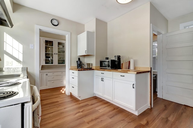 kitchen featuring white cabinets, wood counters, and light hardwood / wood-style flooring