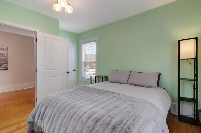 bedroom with a closet, a notable chandelier, and hardwood / wood-style flooring