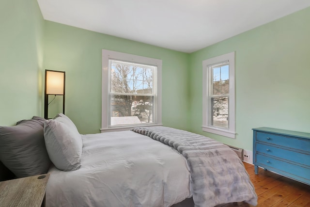 bedroom with light hardwood / wood-style floors and multiple windows